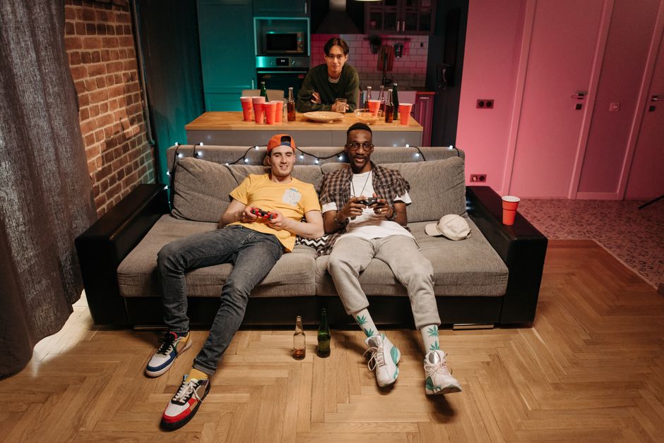 friends playing video games together living room